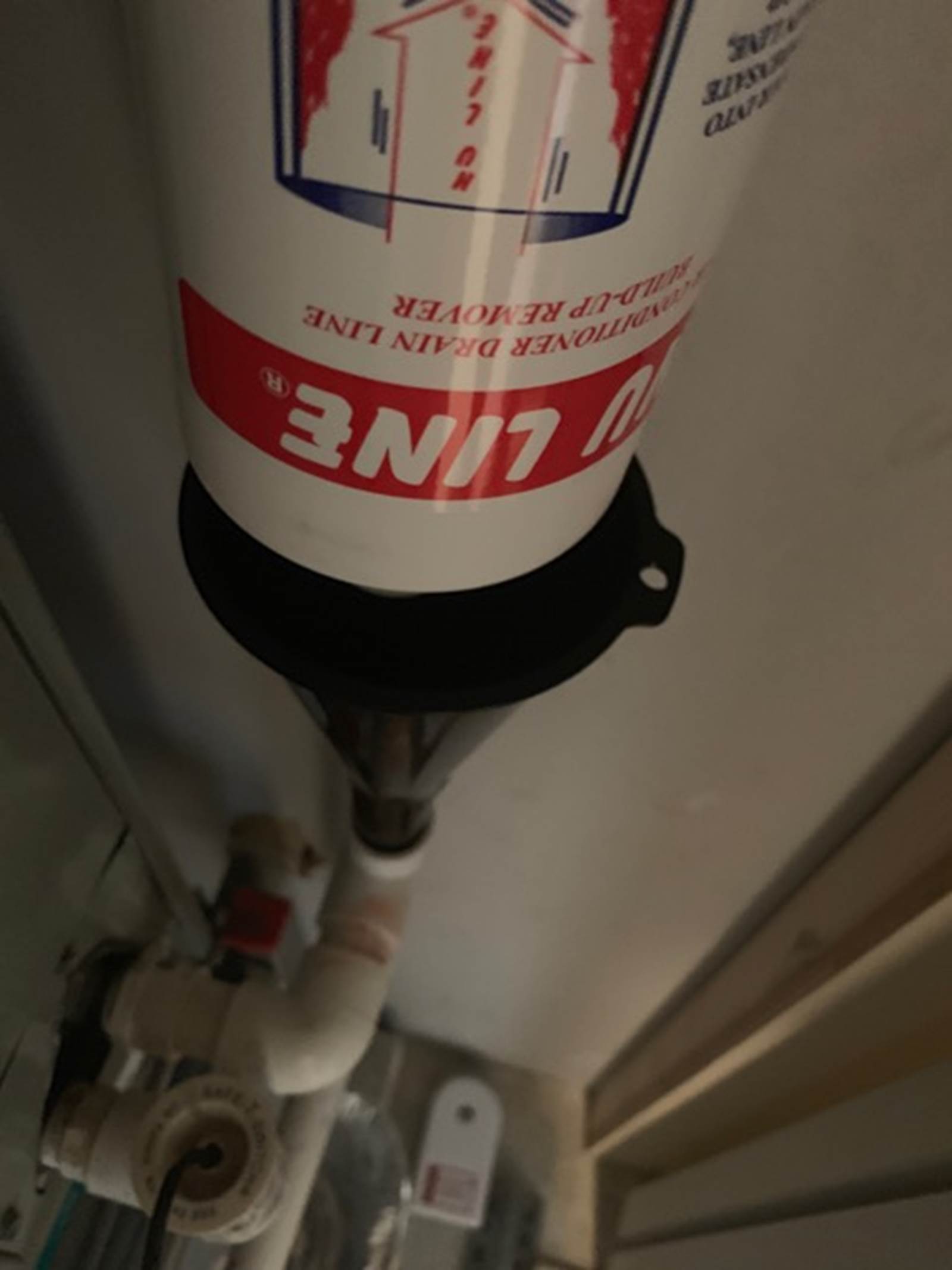 Nu Line (2 oz.) being poured into the condensation drainpipe on the right (using a funnel). 